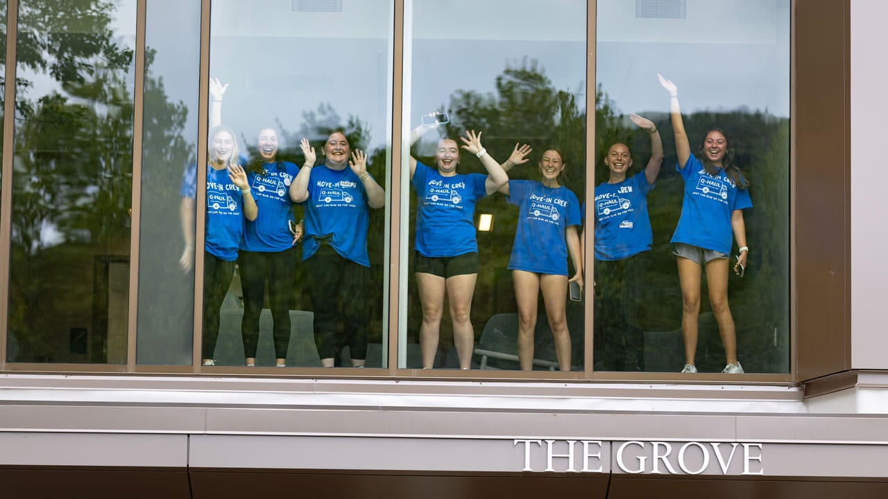 Move in crew participants jump with enthusiasm through the windows of The Grove.