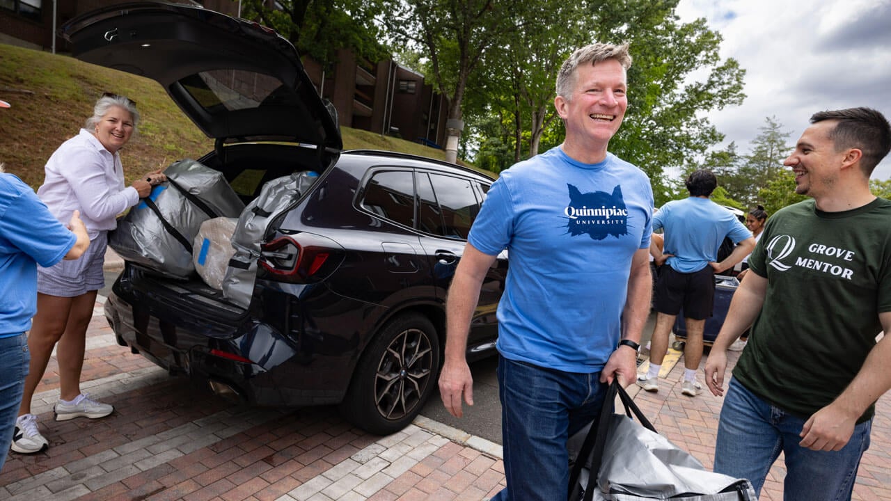 Faculty members help unload first year dorm items.
