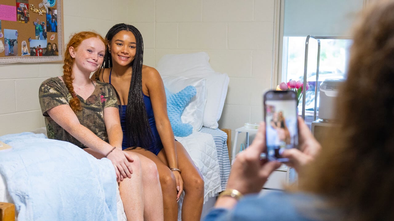 Roommates take a photo in their new dorm.