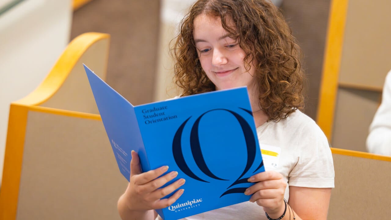 Graduate student reads an informational pamphlet.