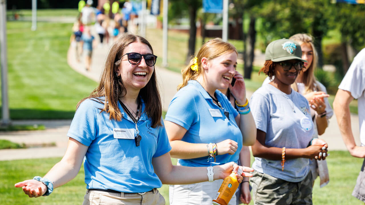 Orientation leaders cheer and smile on the sunny quad