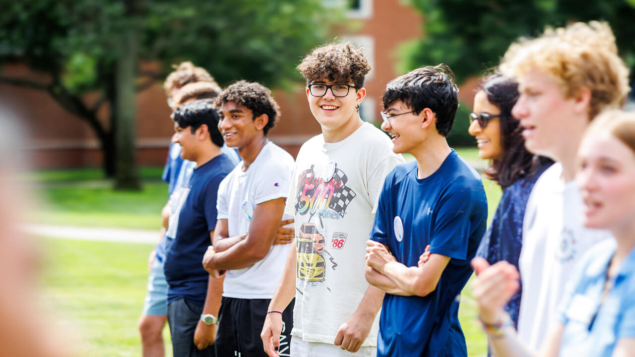 New students stand in a line during an ice breaker game on the quad