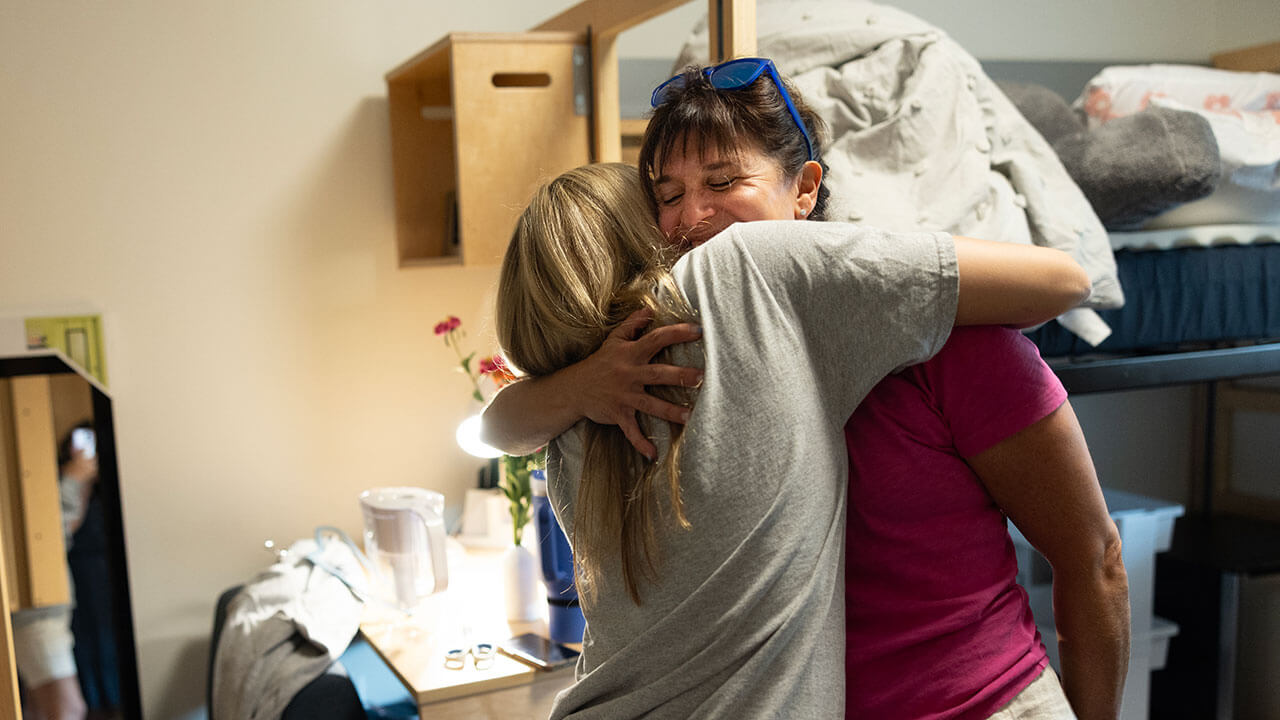A mom hugs her daughter goodbye after move-in