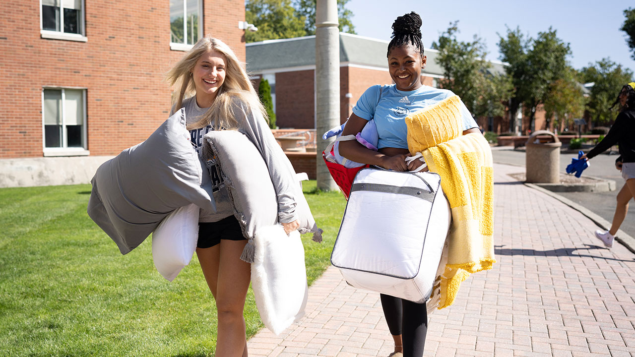 New students carry their pillows into their new residence halls
