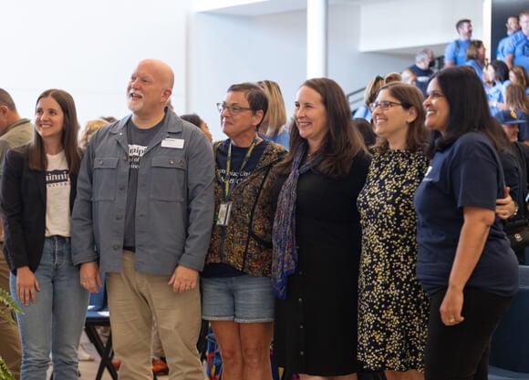 The 2025 Center for Excellence Honorees stand arm in arm in The SITE auditorium