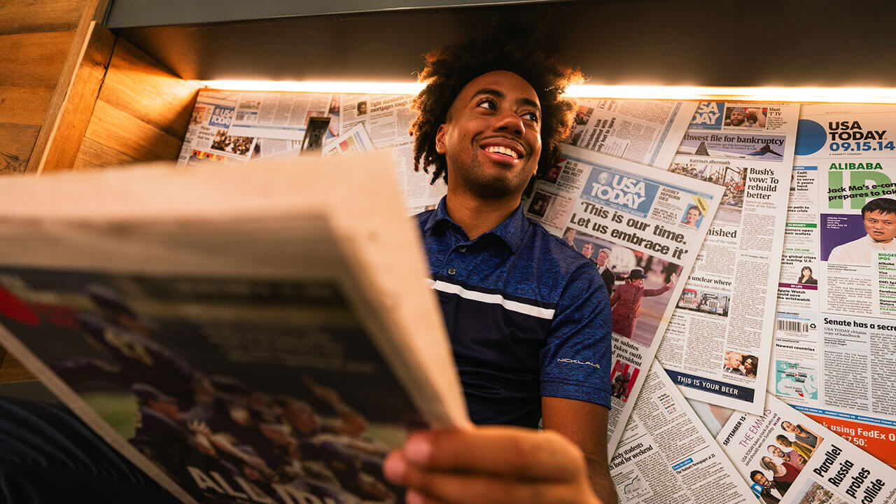 Toyloy Brown holds a copy of USA Today and smiles