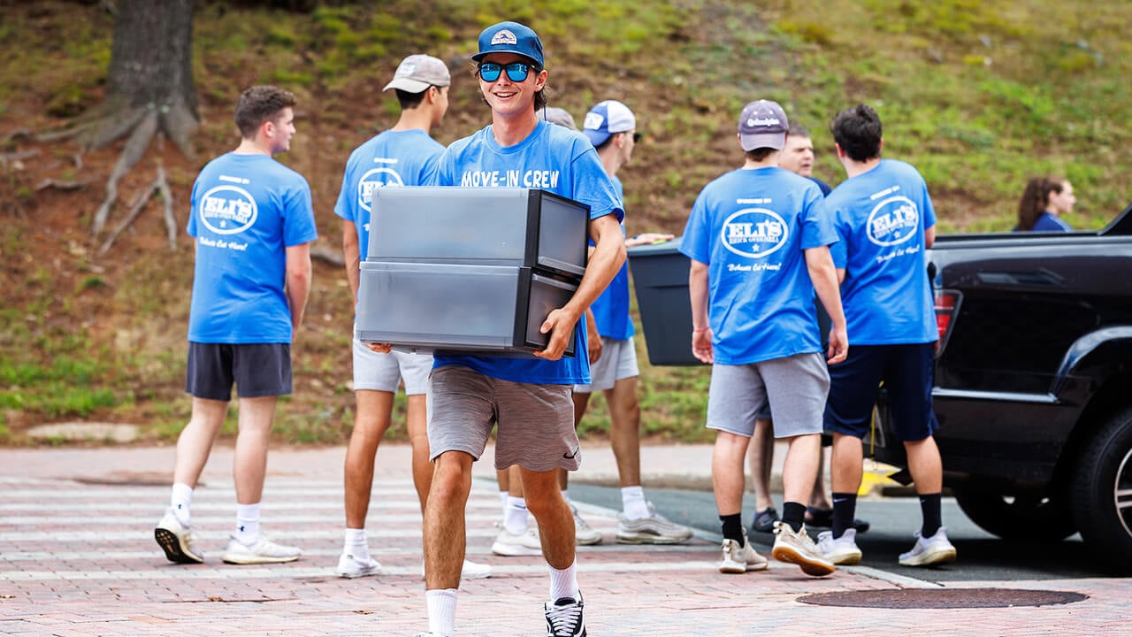 A Move-In Crew volunteer holding two black drawers