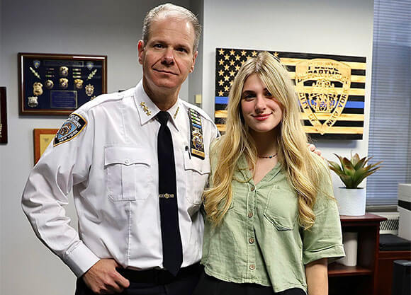 Jacqueline Roberts stands with a member of the NYPD