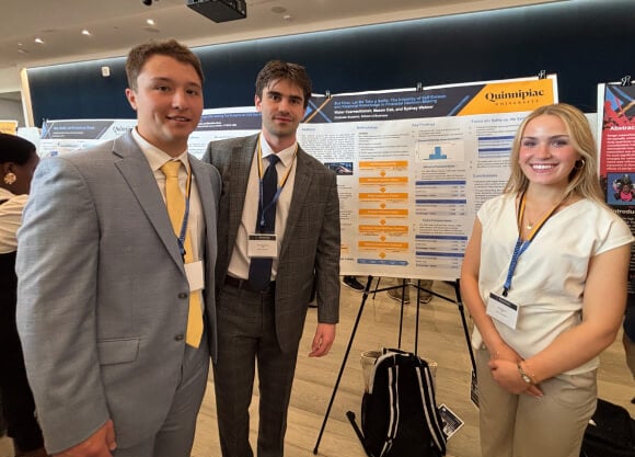 2 male student on the left side of a poster and a female student on the right side, posing for a photo