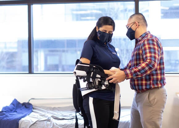 An occupational therapy student and professor test out an arm brace