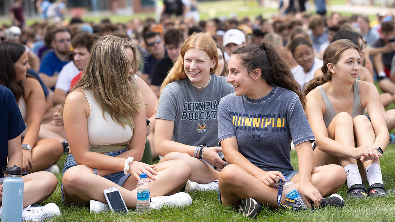 Hundreds of students sit, talk and laugh together on the quad