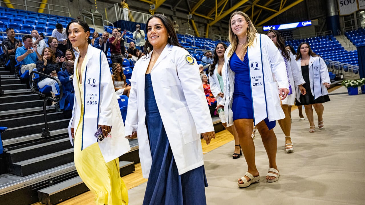 Nurses walking in their white coats at the pinning ceremony