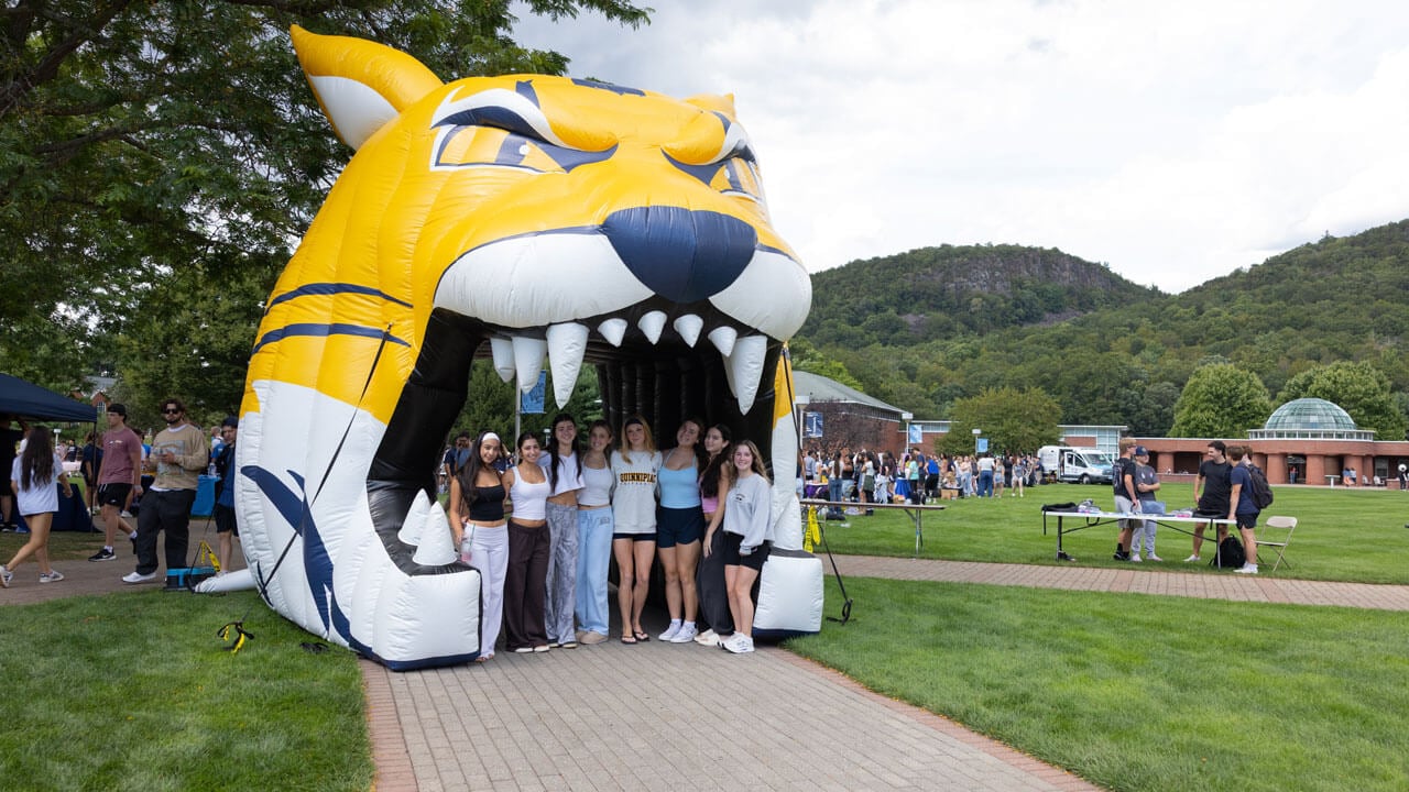 Students pose inside inflatable bobcat tunnel