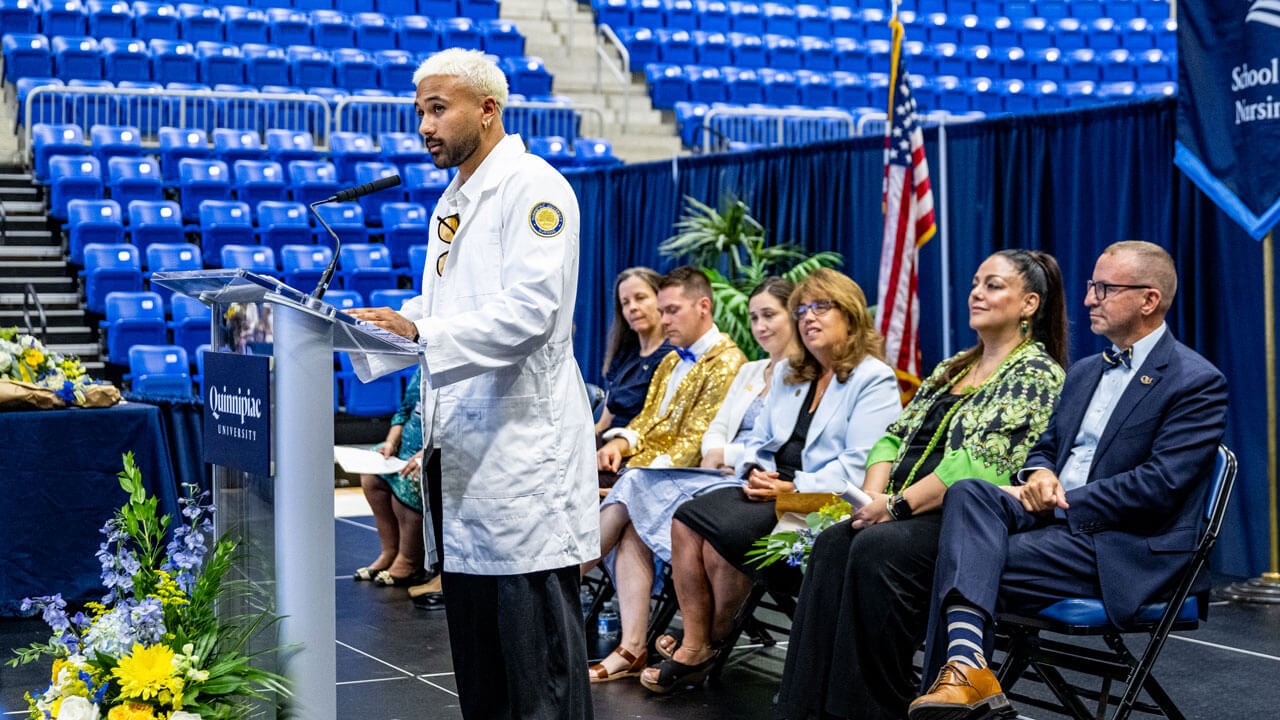 Speaker in white coat talking to a crowd