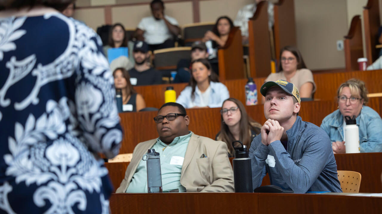 Incoming graduate students listen intently