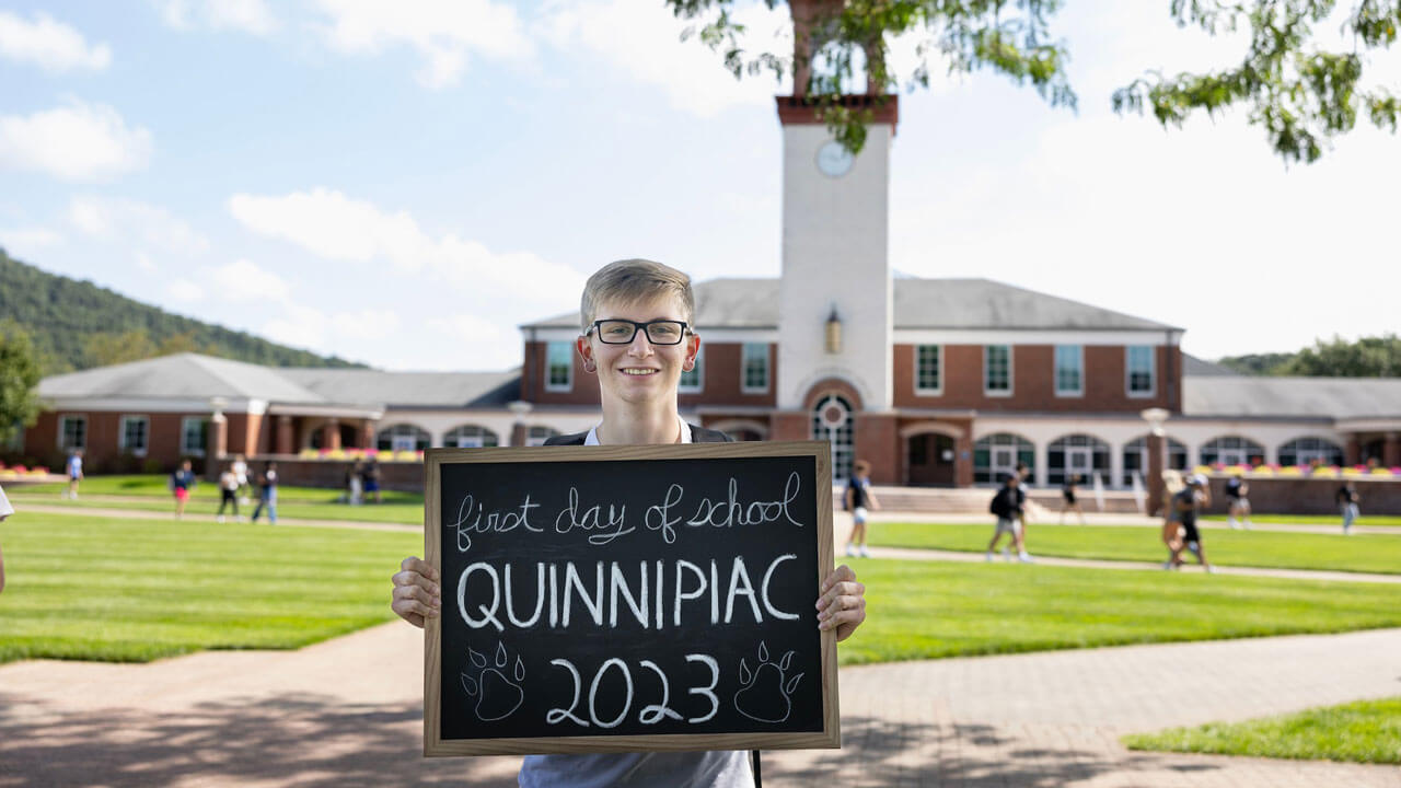Student poses on the first day of school on the quad