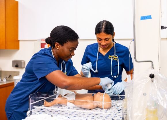 Two nursing students practicing skills on mannequins