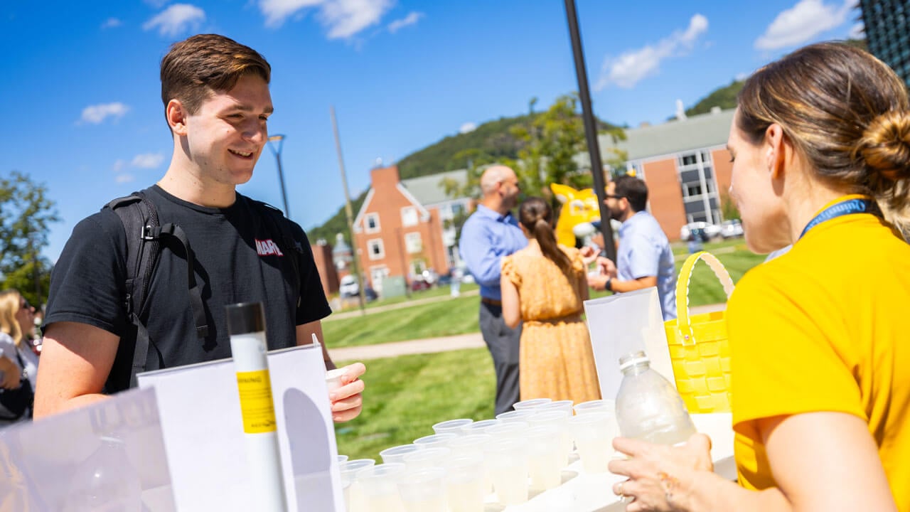 Two students talking at an informational table
