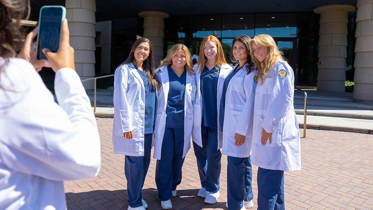 five nursing students pose outside the North Haven campus for their photo to be taken