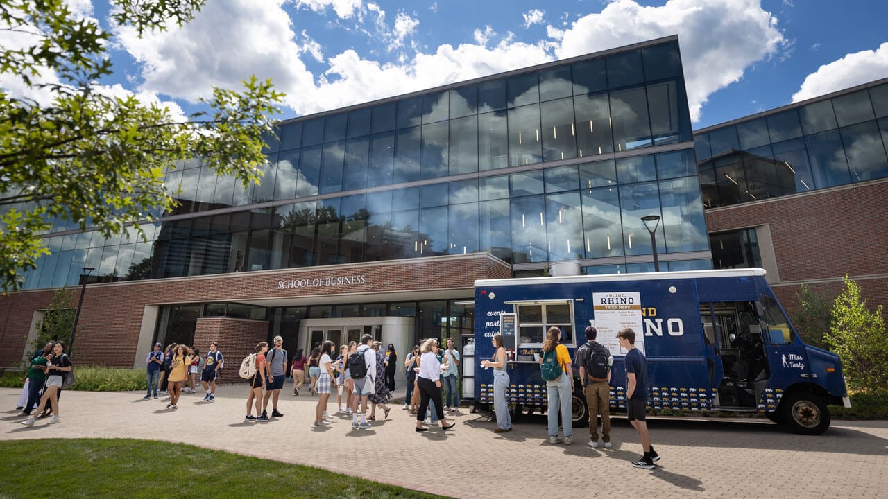 Students line up outside the school of business getting food from a food truck