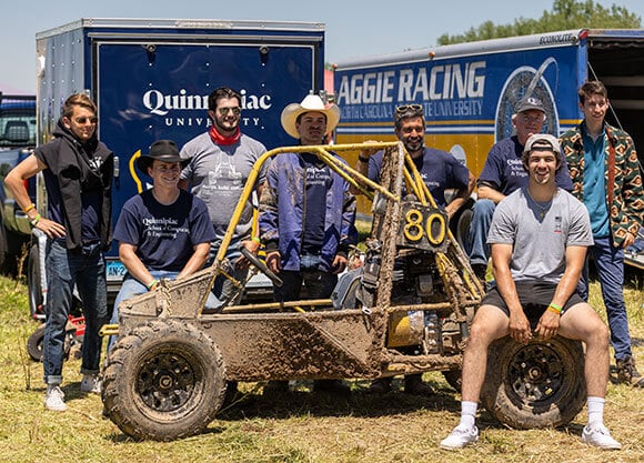QU Baja team engineering students pose for a picture with their winning Baja vehicle