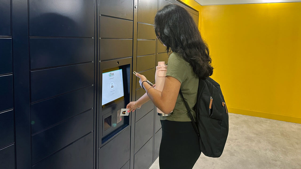 Student tapping Q-Card to retrieve package at locker