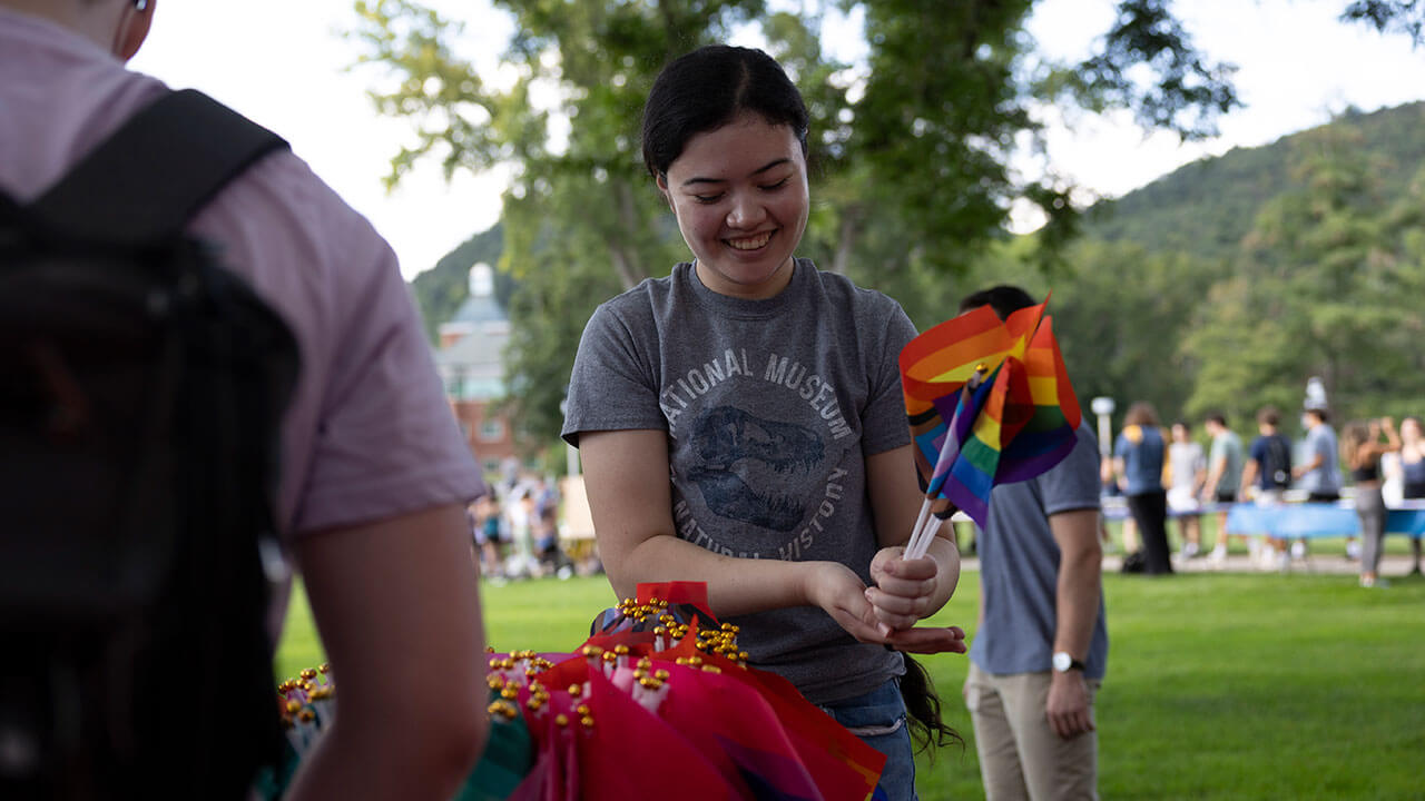 A student picks up pride flags on the Quad