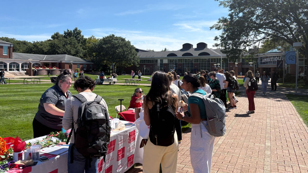 Students walk to all the entrepreneur tables on the quad