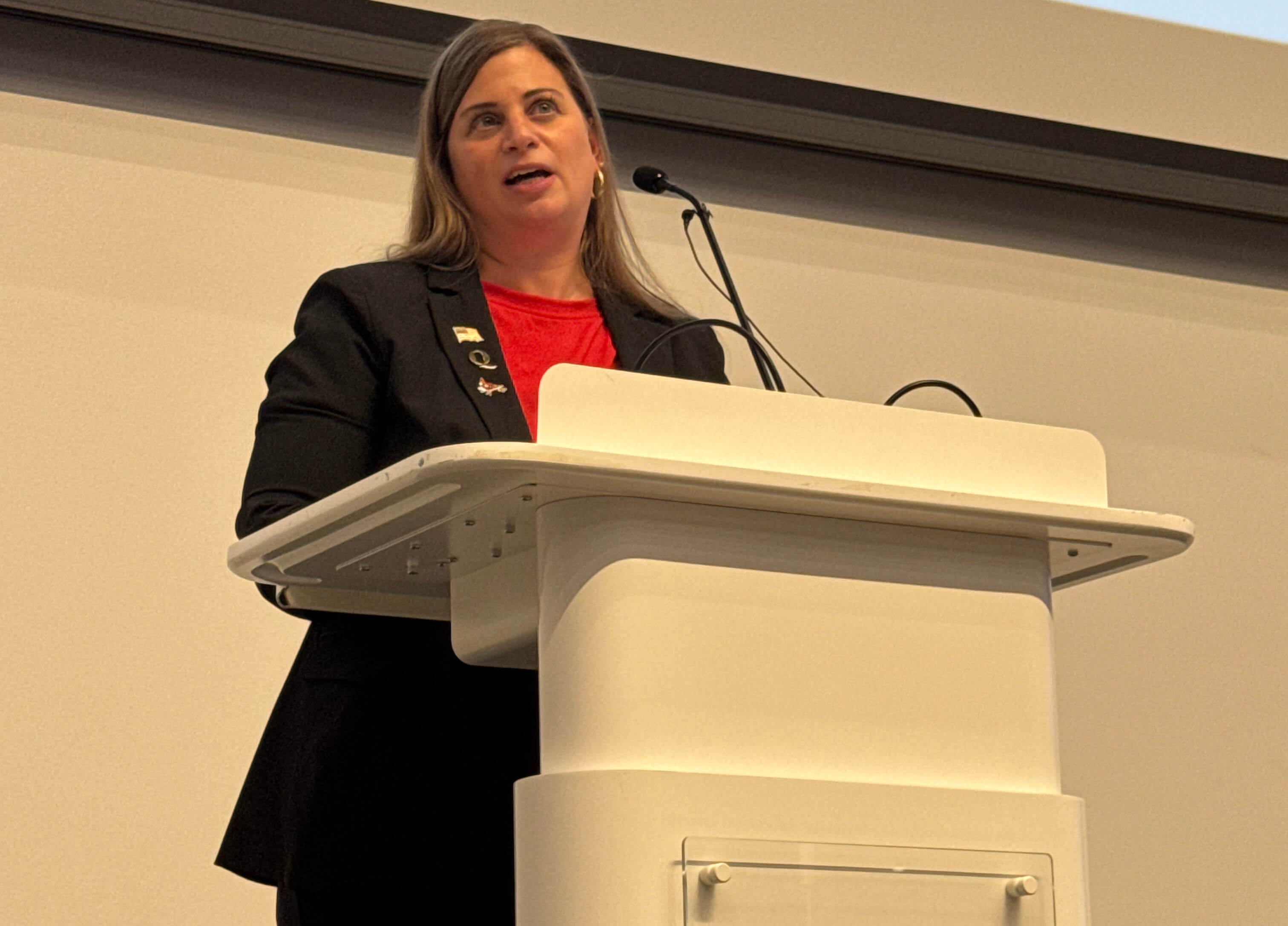 Karla Natale speaks at a podium