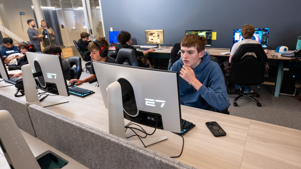 A row of students looking at monitors in the esports lab.