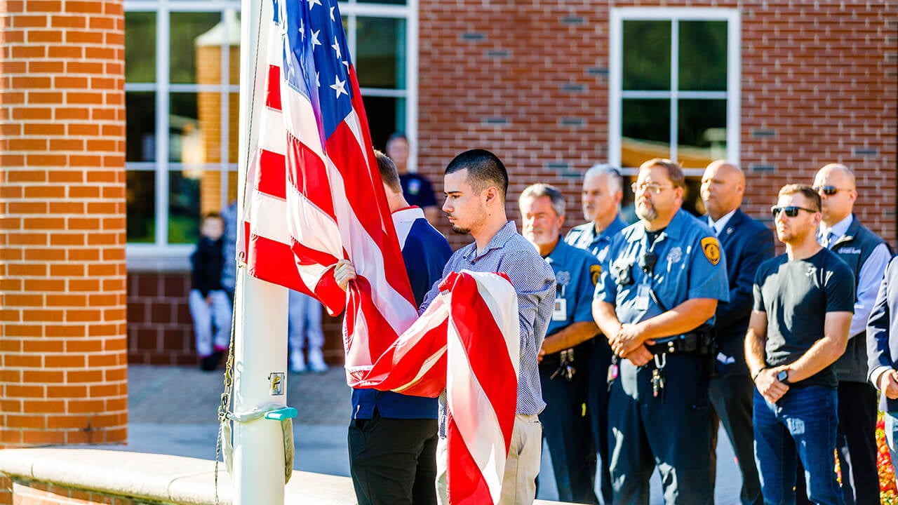 A student veteran holds the flag.