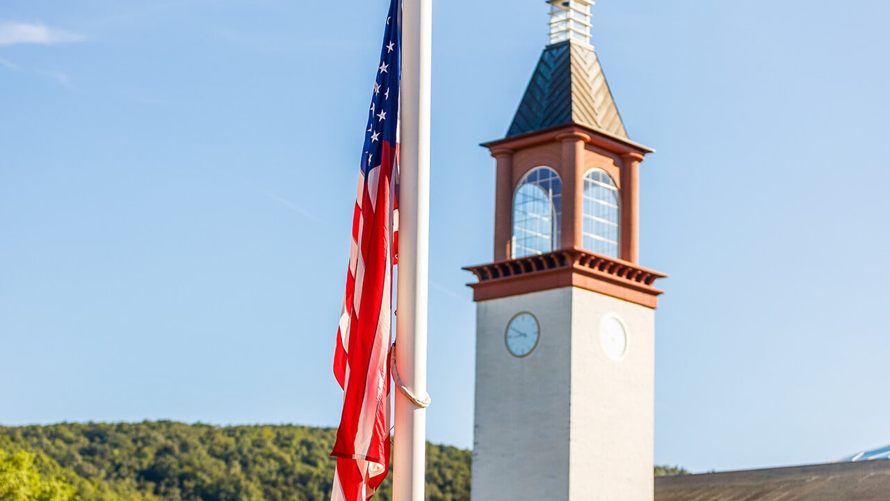 The American flag can be seen in front of the library clocktower.