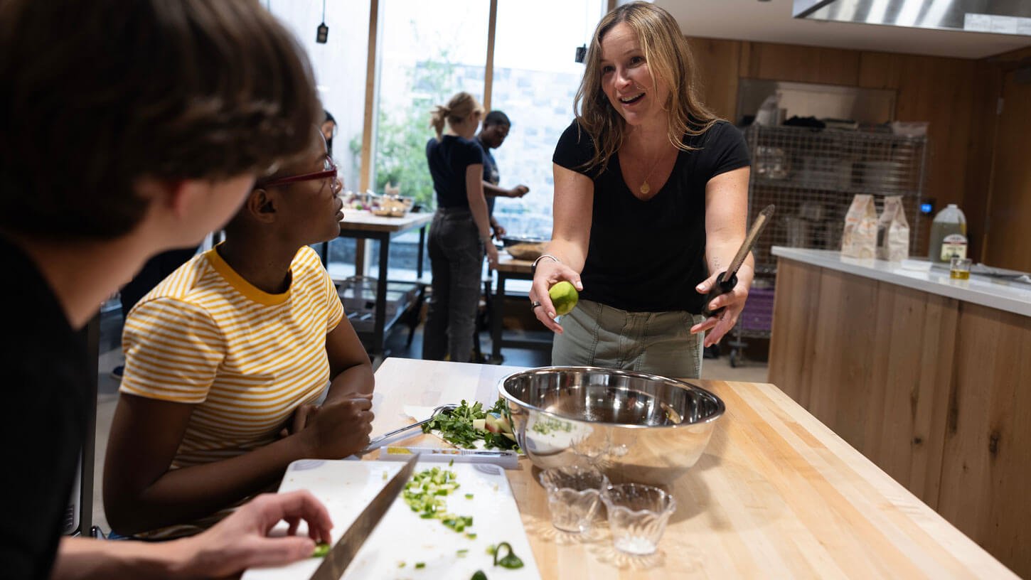 Professor Dana White directs students in a university kitchen.