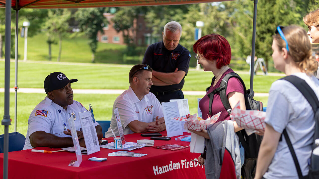 Students talking to the Hamden Fire Department staff at a tent