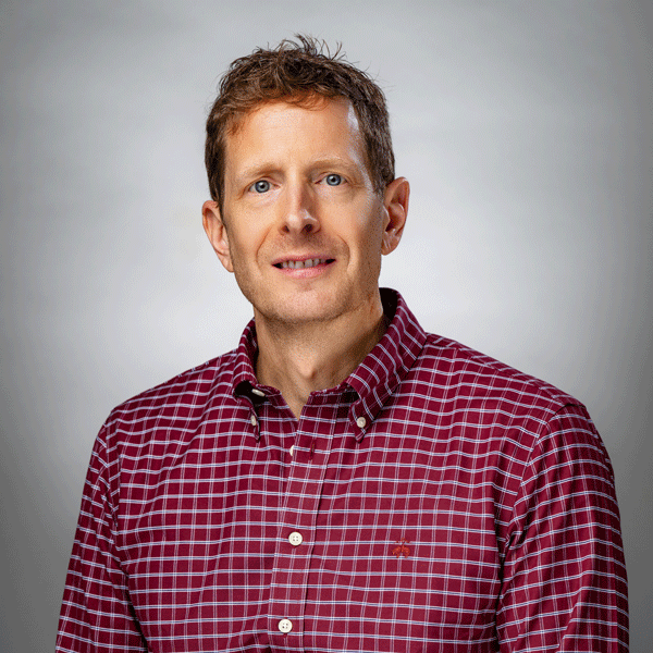 Jeff Lombardo smiles against a grey background