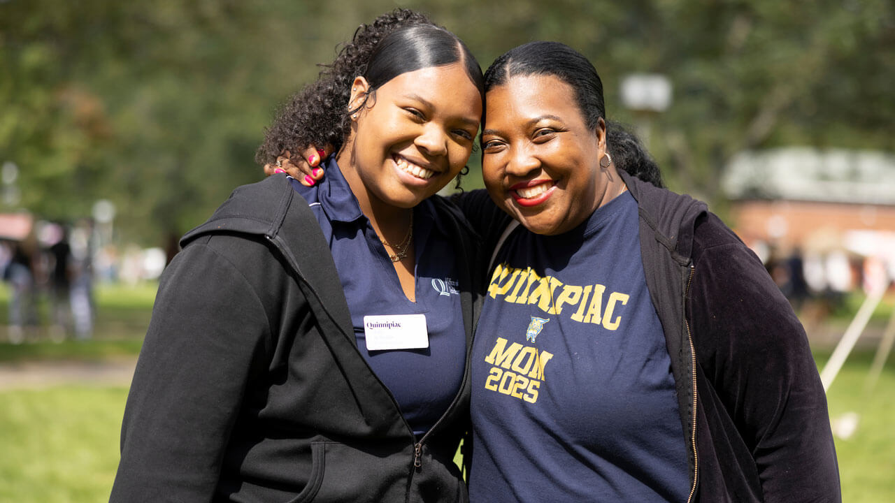 A mother and daughter smiling together and pose for picture at bobcat weekend