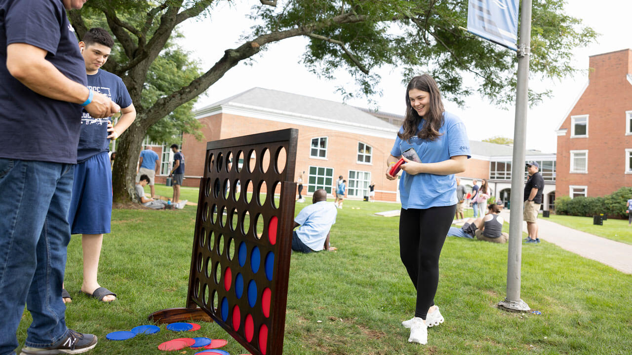 A girl and her family play connect 4 at Bobcat Weekend.