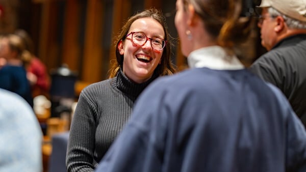 Two women, one in a judge's robe, smiling and having a conversation.