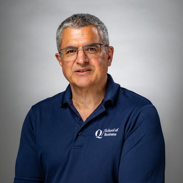 Stan Veliotis standing against a grey background
