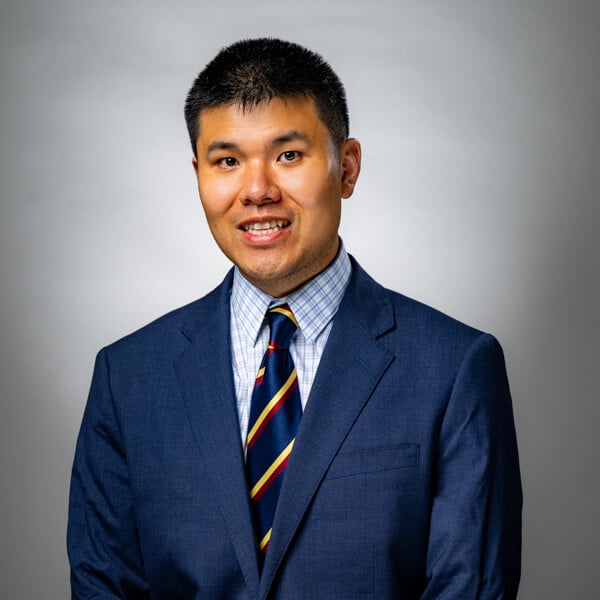Shizhen (Jasper) Jia smiling against a grey background