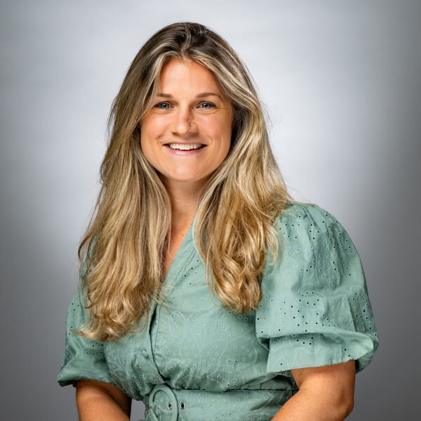 Lisa Haylon smiling against a grey background