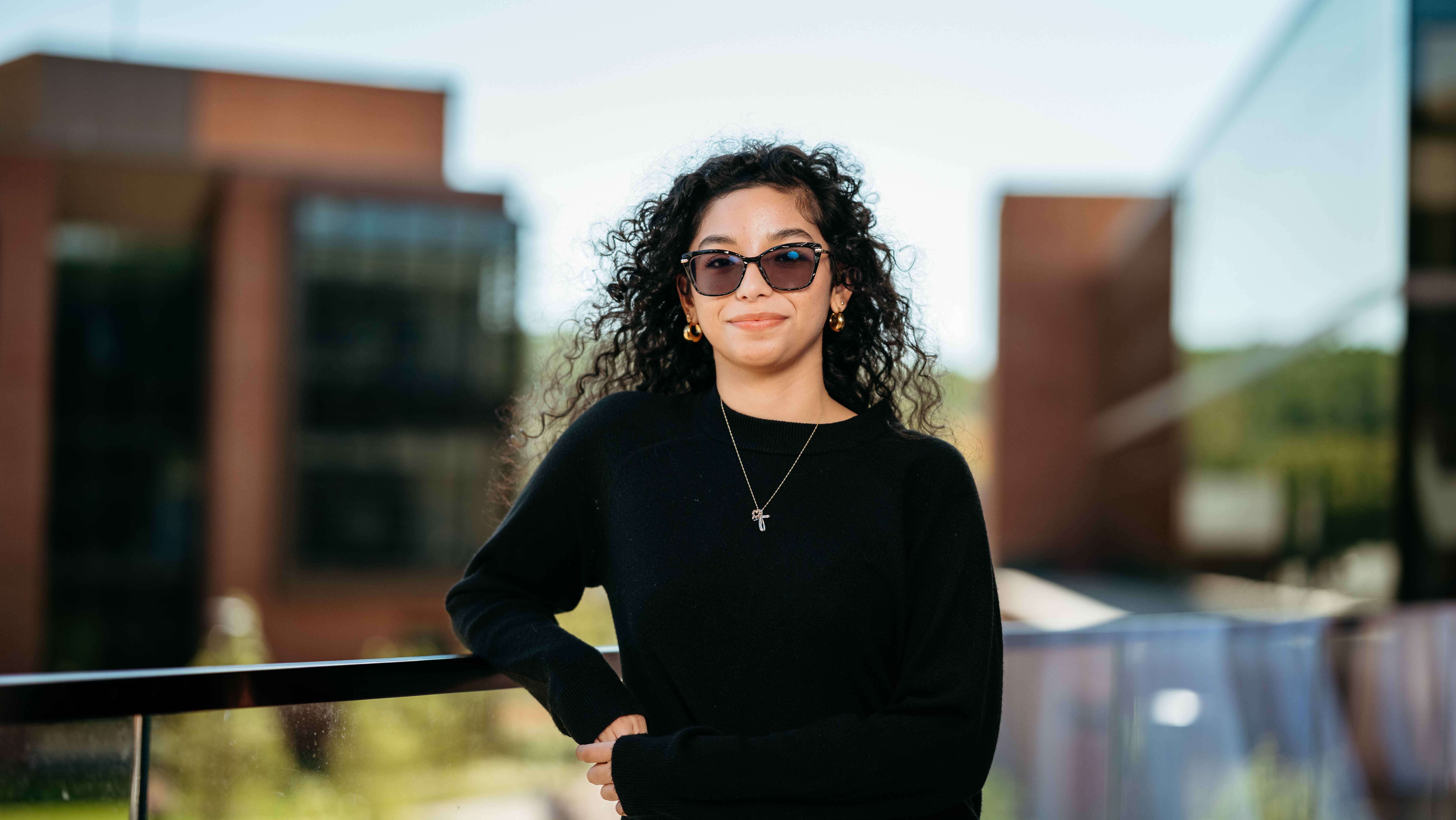 Adriana Bonilla, a Sawhney Leadership fellow, poses for a portrait on the balcony of the School of Business on the South Quad.