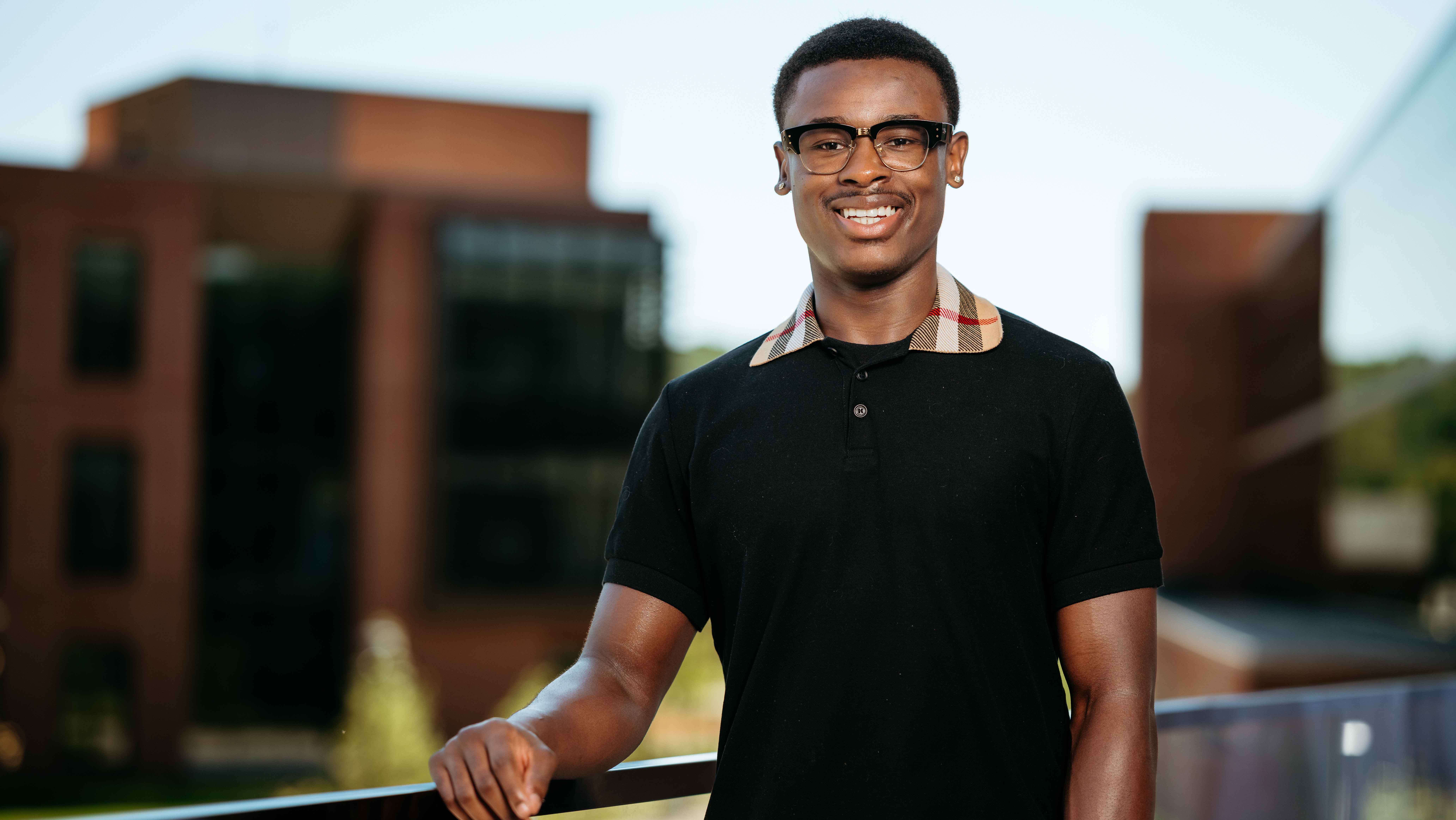 Dajon Dort, a Sawhney Leadership fellow, poses for a portrait on the balcony of the School of Business on the South Quad.