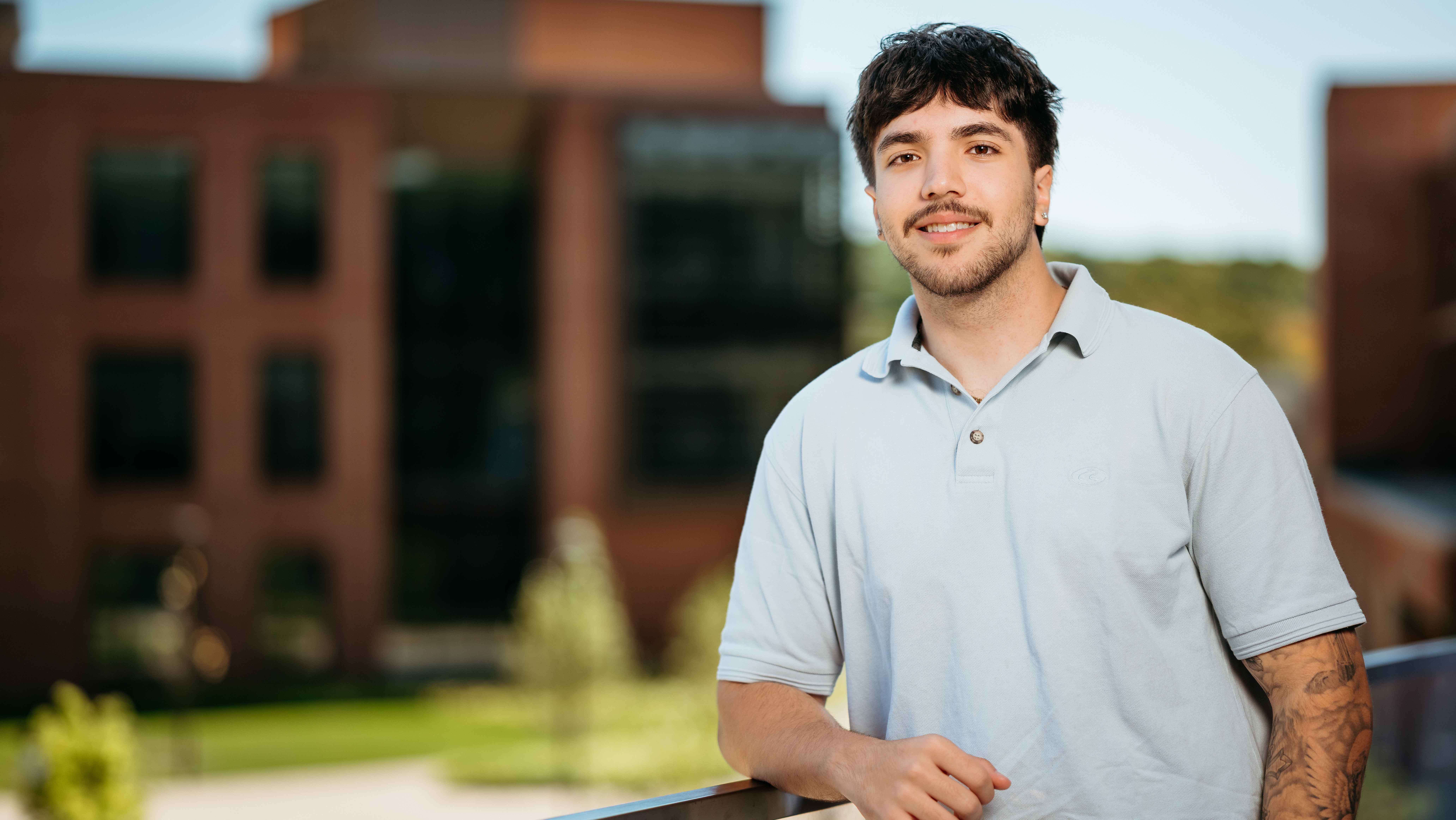 Ethan Jesse Rezende, a Sawhney Leadership fellow, poses for a portrait on the balcony of the School of Business on the South Quad.