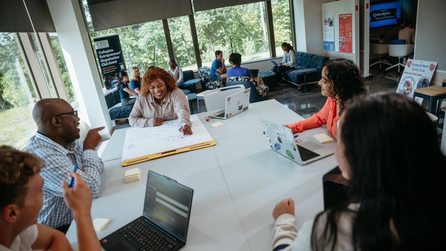 Business professor Robert Yawson collaborates with students in the Innovation Hub.