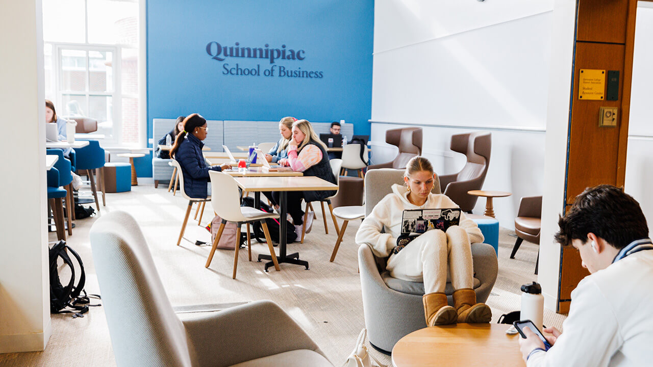 A photo of a group of students studying at their own tables in the School of Business.