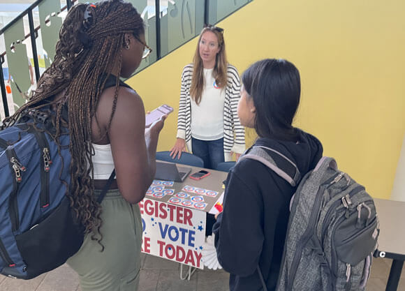 Two students signing up to vote at voting table