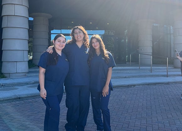 Anita Farid stands in front of the medical school with fellow nursing friends.