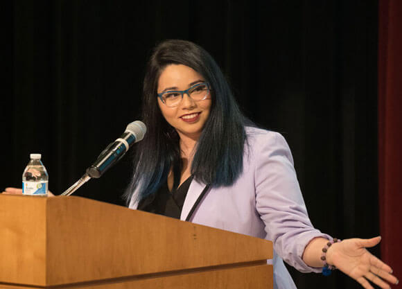 Lux Burgos Lopez speaks at a podium