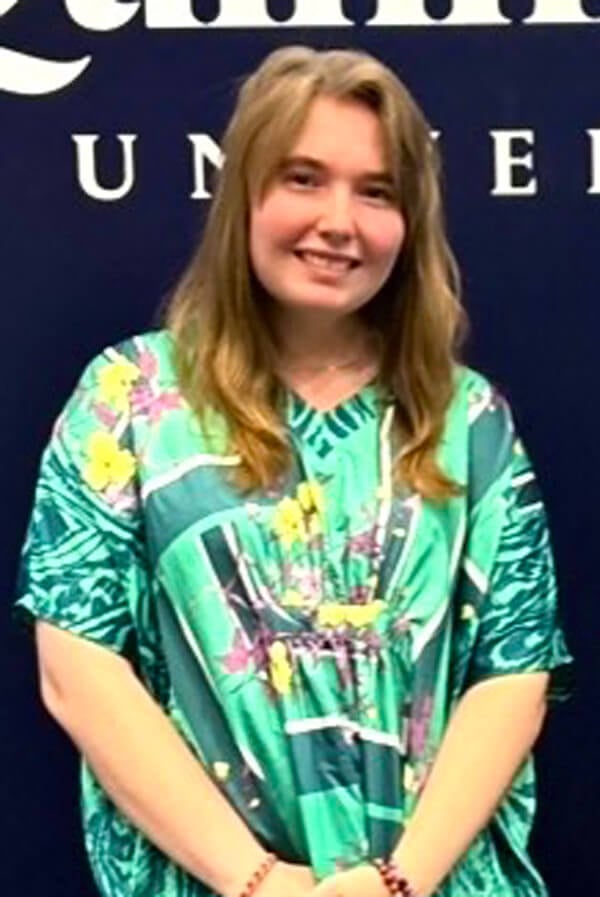 Headshot of Ava Real in front of a Quinnipiac banner.
